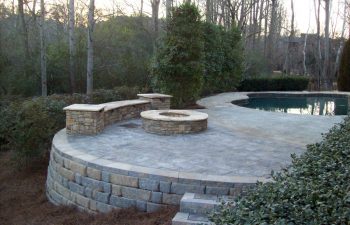 backyard stone patio with fire pit and Koi pond