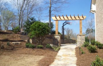 wooden arbor with stone bases and garden stone walkway by Mobile Joe's Landscaping