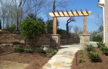 wooden arbor with stone bases and garden stone walkway by Mobile Joe's Landscaping