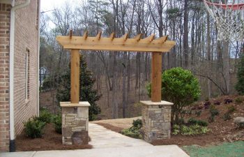 wooden arbor with stone bases by Mobile Joe's Landscaping