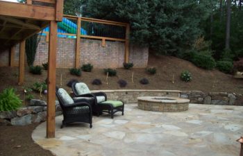 flagstone patio with a fire pit and two garden armchairs