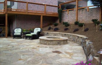 flagstone patio with a fire pit and two garden armchairs